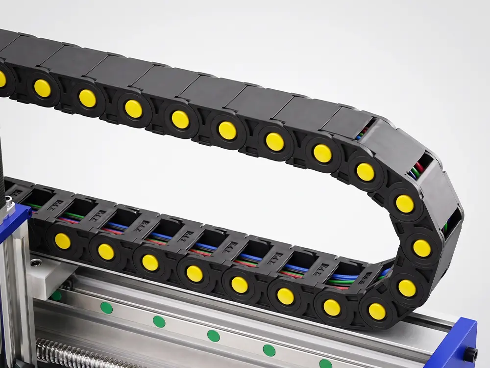Drag chain cable management system on the CNC Router, designed to organize cables and coolant hoses while protecting them from bending, wear, and damage during continuous machine operation.